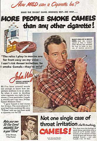 John Wayne Advertises Camel Cigarettes, seated in a relaxed pose, wearing a plaid shirt, 1950s.